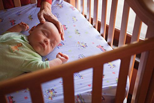 getty_rm_photo_of_mother_putting_baby_down_to_sleep-493x330